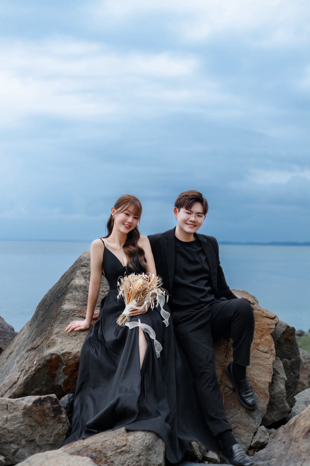 Clifford and Shuzhen dressed in black beside the sea